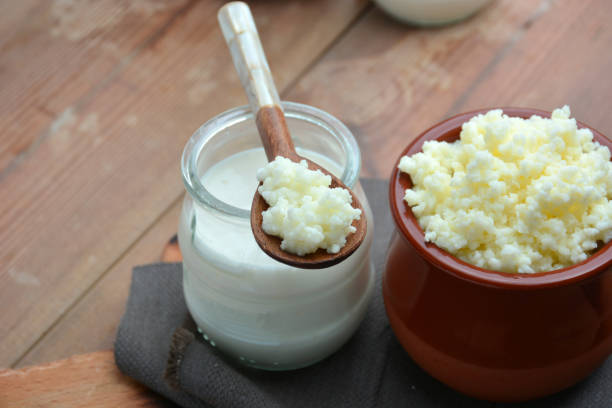 full of keffir, milk and yogurt cups liquid on wooden table
